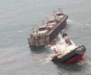 八戸港内で座礁し、二つに割れたパナマ船籍の貨物船。手前に流出した油が見える＝12日午前（第2管区海上保安本部提供）