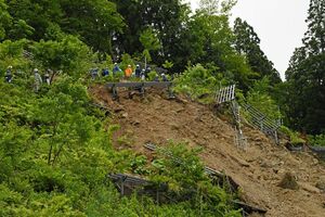 土砂が崩落した斜面では、検討委員会のメンバーによる視察が行われた＝7日午前10時40分、西目屋村砂子瀬