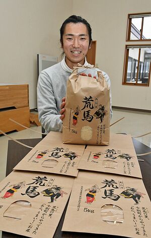 荒馬の文字や絵をデザインした米袋を紹介する岡田さん