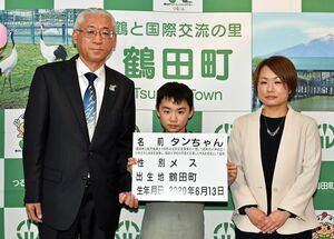 相川町長（左）から表彰を受けた名付け親の千葉君（中）と公美さん