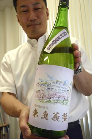 日本酒「花牡丹」を手にする漆澤さん