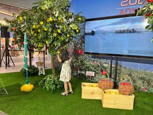 台湾のショッピングセンターに開設した模擬リンゴ園で収穫を体験する子ども（県りんご対策協議会提供）