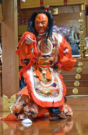 谷地頭神社で、清野さん制作の舞楽面を着けて奉納舞を披露する権禰宜＝9月24日