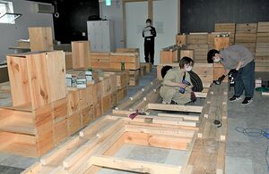 「リンゴ箱ベッド」の製作作業。八戸工業大学の学生らが協力している＝弘前オランド