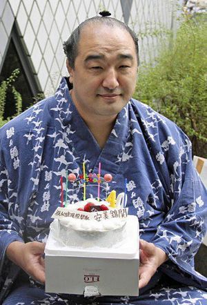 40歳の誕生日を迎え、贈られたケーキを持つ十両安美錦＝3日、東京都大田区