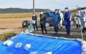 七戸川の堤防決壊現場で、国の担当者らに現場の状況などを説明する県職員