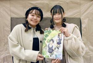 制作したアニメのポスターを持つ小川彩佳さん（左）ら＝２７日午後、埼玉県越谷市
